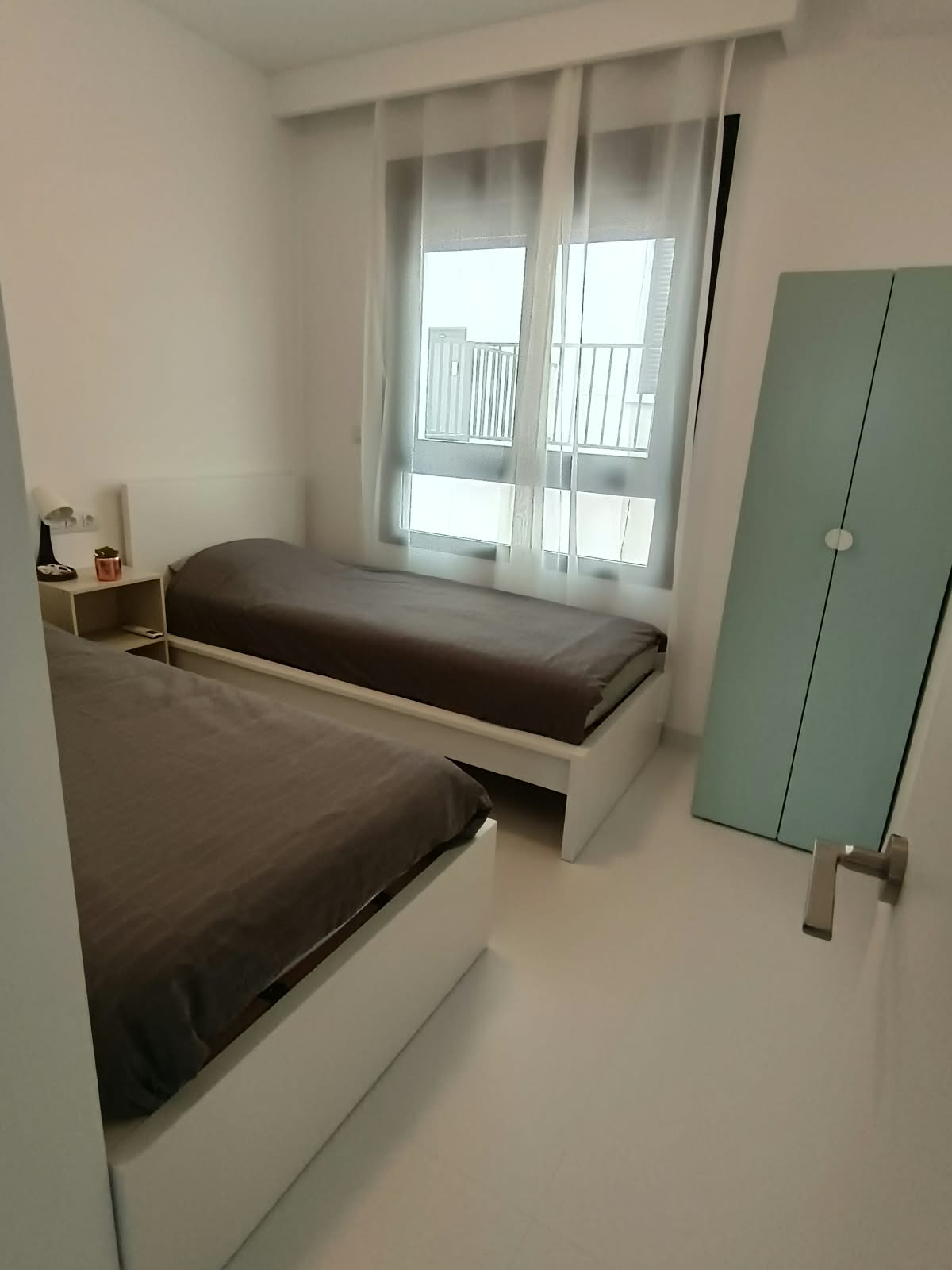 Slaapkamer met twee eenpersoonsbedden en kast