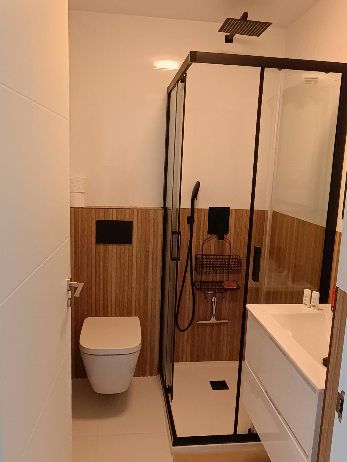 Badkamer met douche en houten wandpaneel